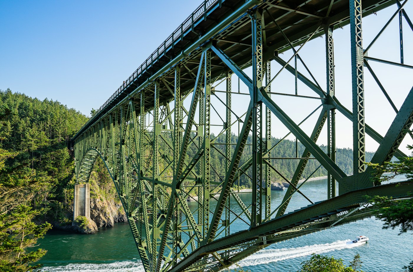 Close view of the green steel truss of Deception Pass Bridge above the water
